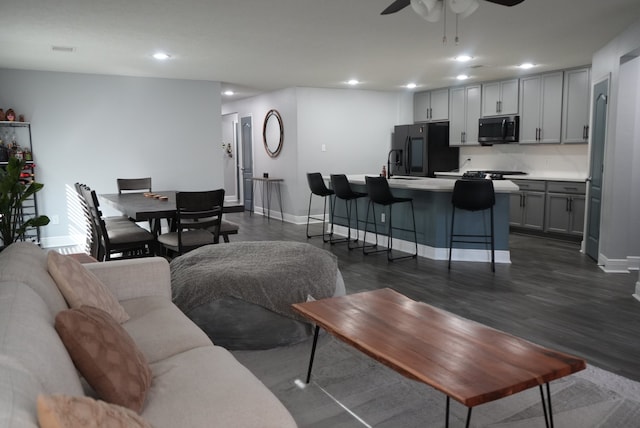 living room with ceiling fan, sink, and dark hardwood / wood-style flooring