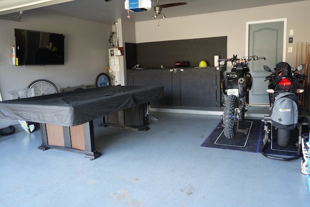 playroom featuring ceiling fan, pool table, gas water heater, and concrete flooring