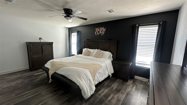 bedroom with dark hardwood / wood-style flooring, multiple windows, a textured ceiling, and ceiling fan