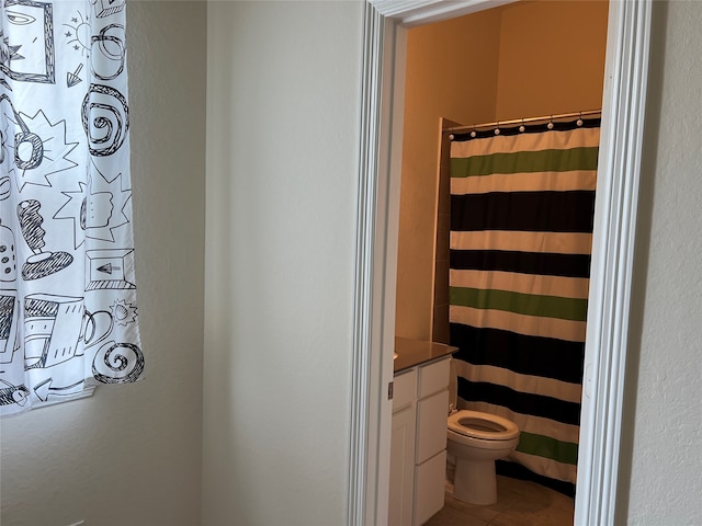 bathroom featuring toilet, a shower with curtain, vanity, and tile patterned flooring