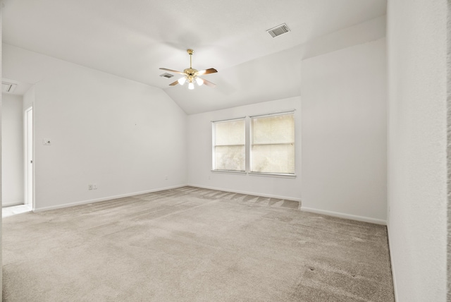 carpeted spare room featuring ceiling fan and vaulted ceiling