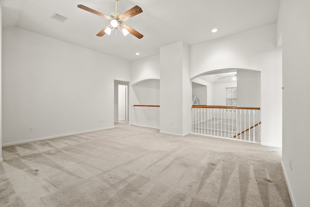 spare room featuring light carpet, high vaulted ceiling, and ceiling fan