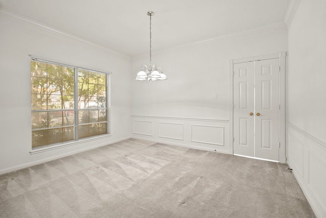 carpeted empty room featuring an inviting chandelier and ornamental molding