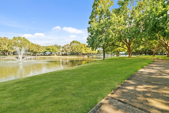 view of property's community with a yard and a water view