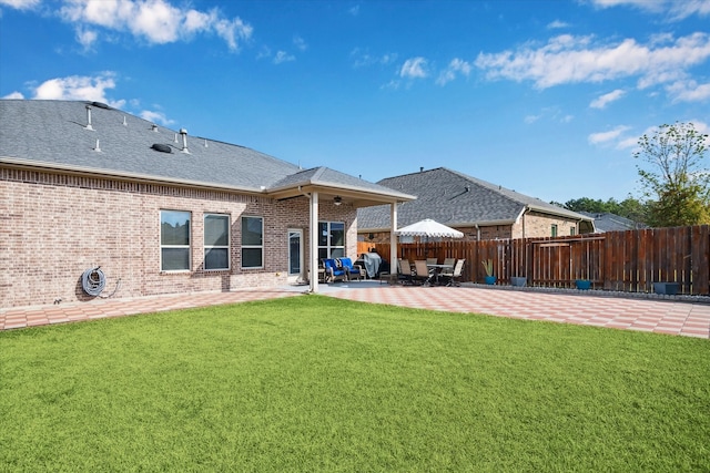 back of property featuring a patio and a lawn