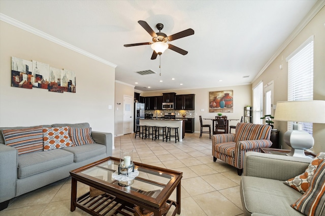 living room with crown molding, ceiling fan, and light tile patterned floors