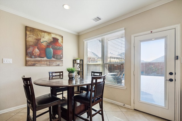 dining room with crown molding and light tile patterned flooring