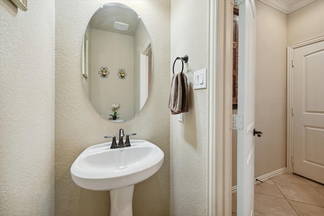 bathroom with ornamental molding, sink, and tile patterned flooring