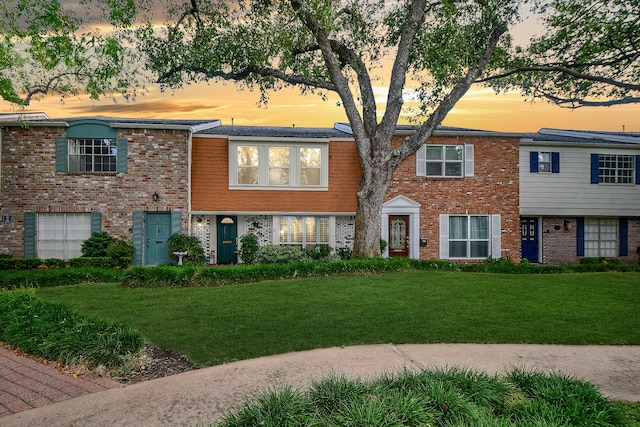 view of front facade featuring brick siding and a front lawn