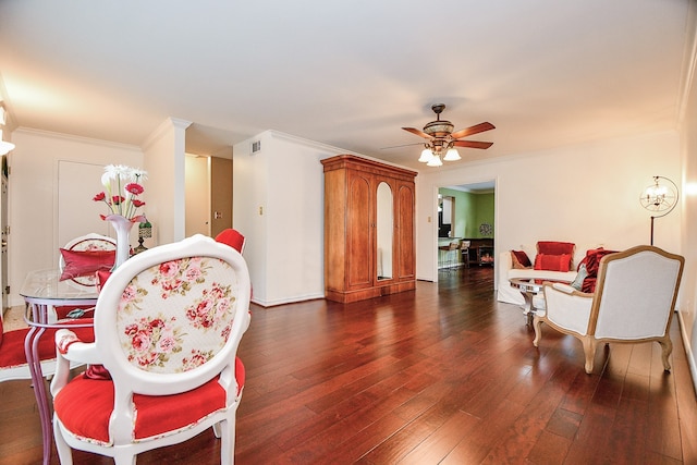 living area featuring dark wood-type flooring, ceiling fan, and crown molding