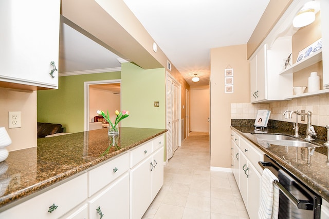 kitchen with backsplash, dark stone countertops, sink, light tile patterned flooring, and white cabinets