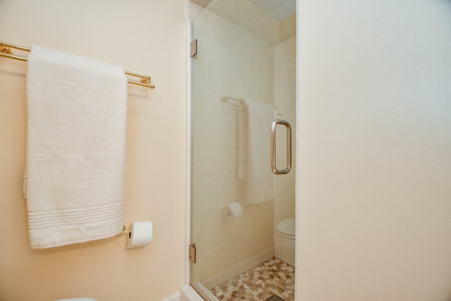 bathroom featuring toilet and an enclosed shower