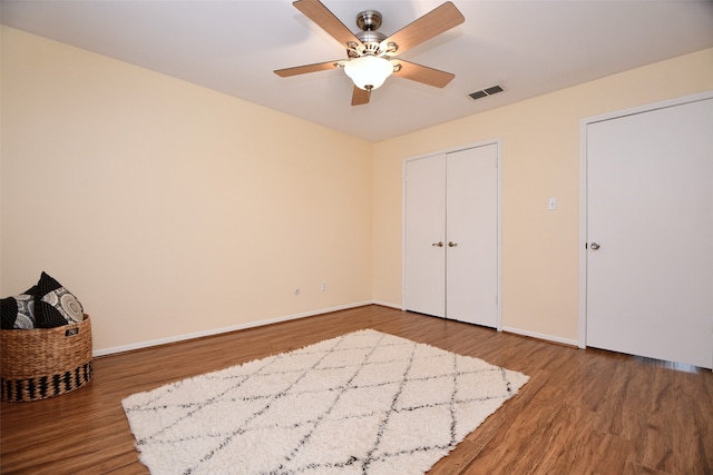 unfurnished bedroom with wood-type flooring, a closet, and ceiling fan