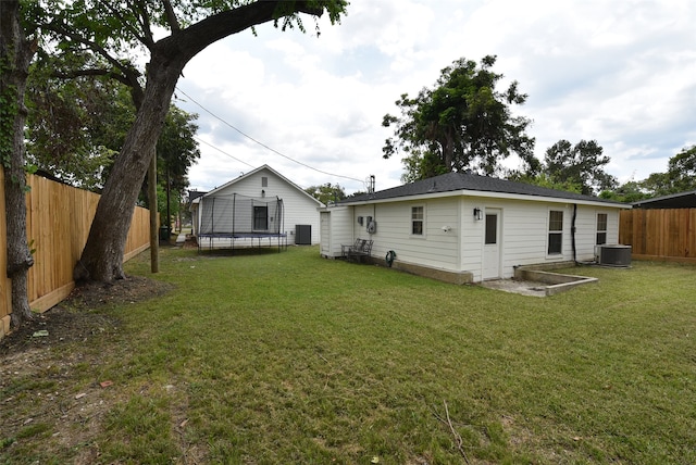 back of house featuring cooling unit and a lawn