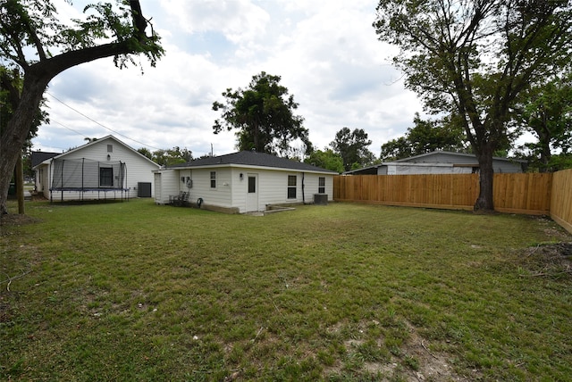 view of yard with a trampoline and central AC unit