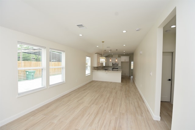 unfurnished living room with a wealth of natural light and light wood-type flooring