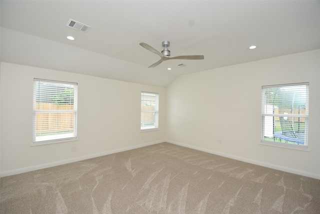 carpeted spare room featuring vaulted ceiling and ceiling fan