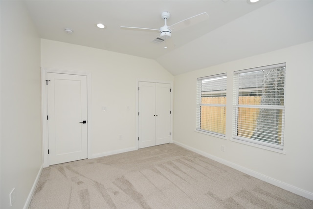 interior space with light colored carpet, vaulted ceiling, and ceiling fan