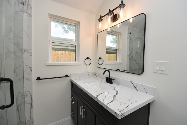 bathroom featuring a shower with door, vanity, and a healthy amount of sunlight