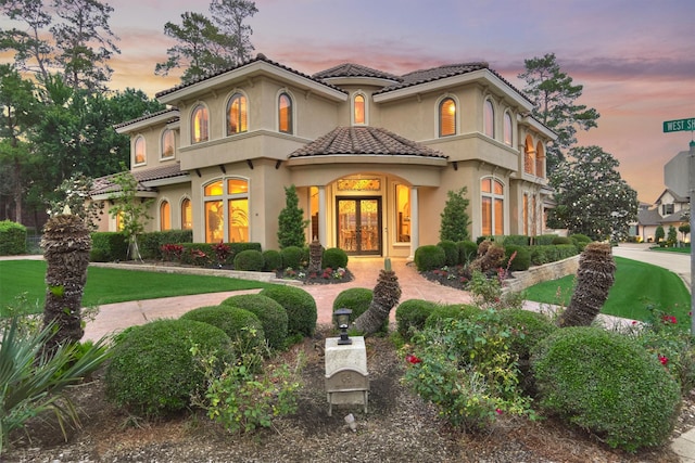 mediterranean / spanish home with french doors and a yard