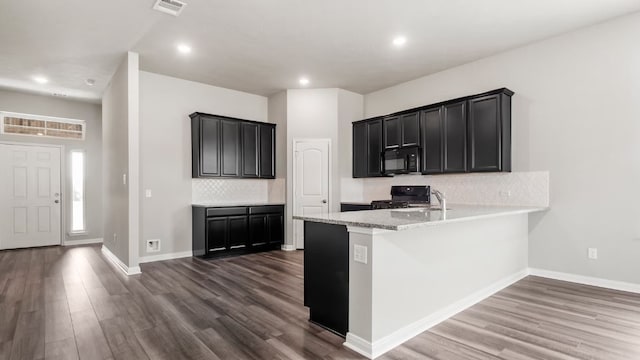 kitchen with black appliances, decorative backsplash, dark hardwood / wood-style floors, and plenty of natural light