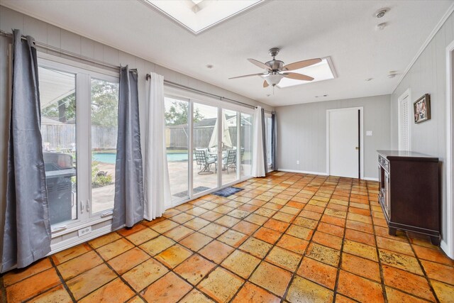 spare room with ceiling fan, a skylight, and a healthy amount of sunlight