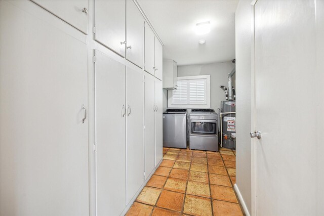 interior space with white cabinetry, gas water heater, and separate washer and dryer