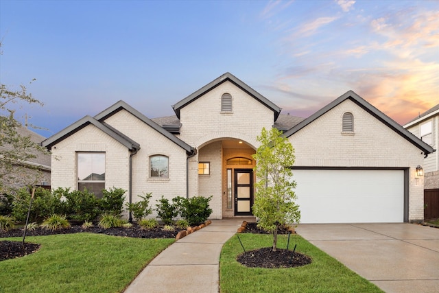 french provincial home featuring a yard and a garage