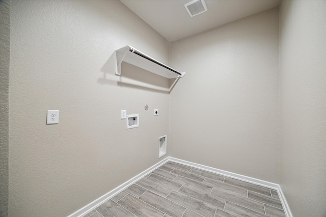 laundry room featuring hookup for a gas dryer, light hardwood / wood-style flooring, electric dryer hookup, and hookup for a washing machine