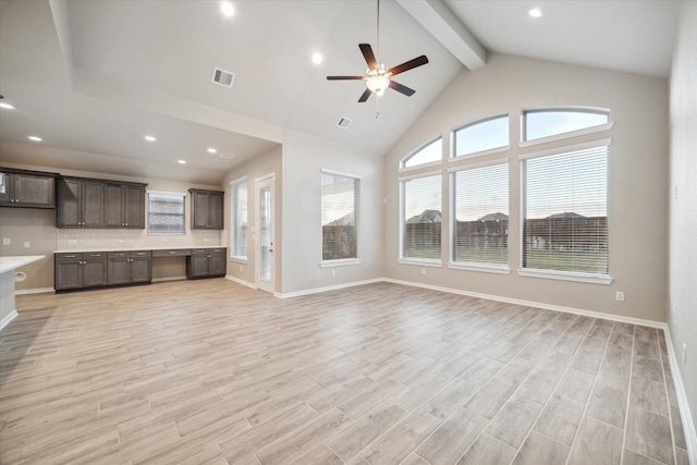 unfurnished living room with ceiling fan, beamed ceiling, and light wood-type flooring