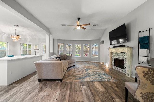 living room featuring wood-type flooring, ceiling fan with notable chandelier, and lofted ceiling