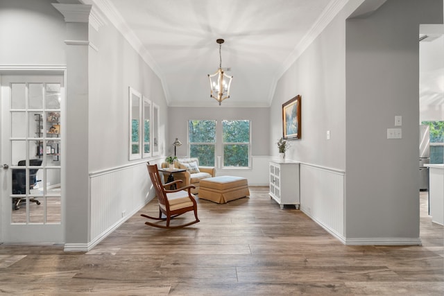 sitting room with ornamental molding, wood-type flooring, a chandelier, and lofted ceiling