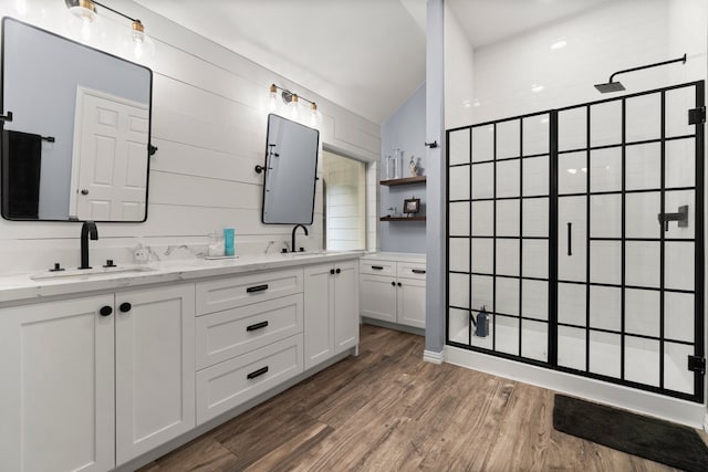 bathroom featuring lofted ceiling, vanity, hardwood / wood-style flooring, and a shower