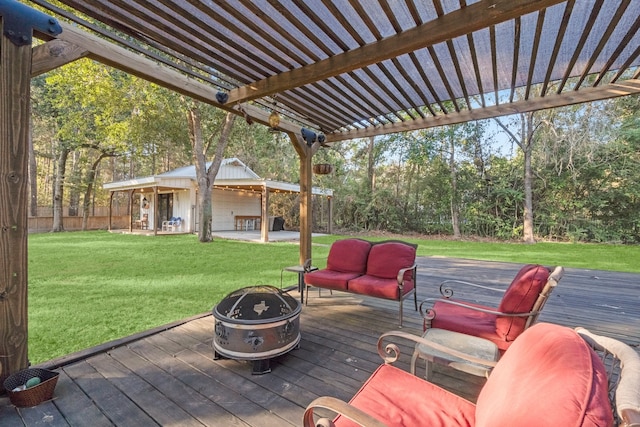 wooden deck featuring a yard, an outdoor structure, and a fire pit