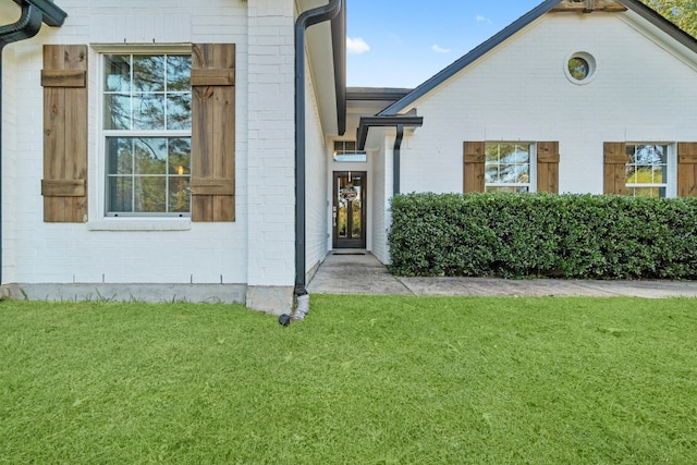 view of exterior entry with a yard