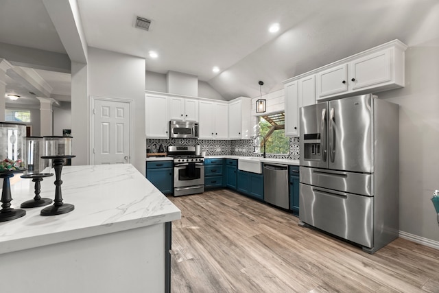 kitchen with stainless steel appliances, white cabinets, decorative light fixtures, and blue cabinets