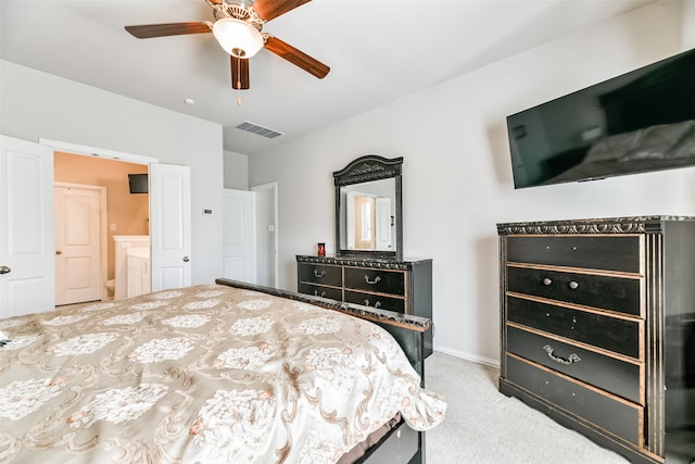 bedroom with light carpet, ensuite bathroom, and ceiling fan