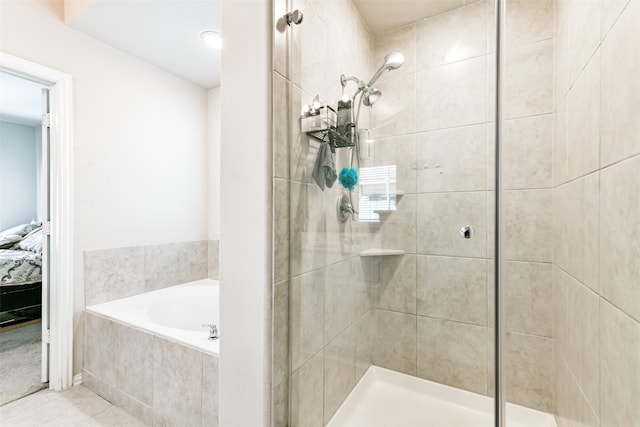 bathroom with separate shower and tub and tile patterned floors