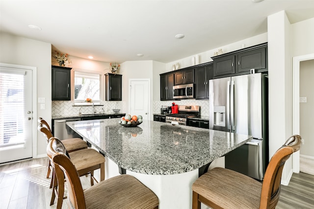 kitchen with stainless steel appliances, a healthy amount of sunlight, and dark stone counters