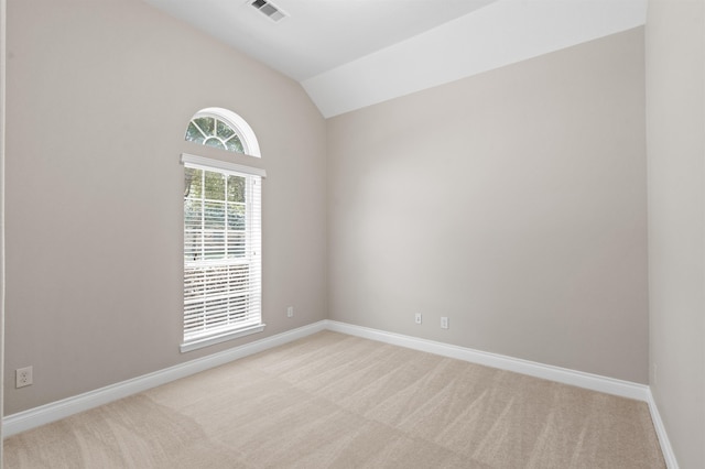 empty room featuring light carpet and lofted ceiling