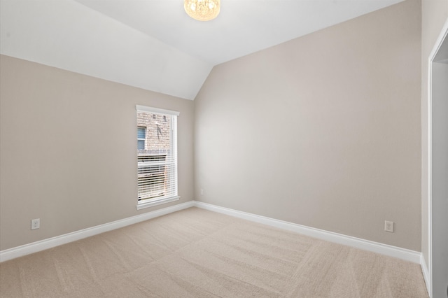 unfurnished room featuring vaulted ceiling and light colored carpet