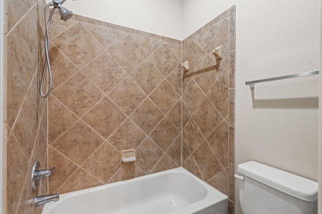 bathroom with toilet and tiled shower / bath