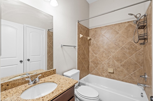 full bathroom with vanity, tiled shower / bath combo, and toilet