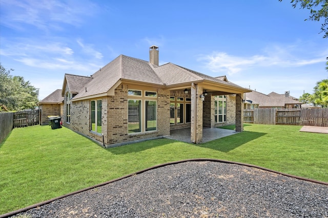 rear view of house with a patio and a yard