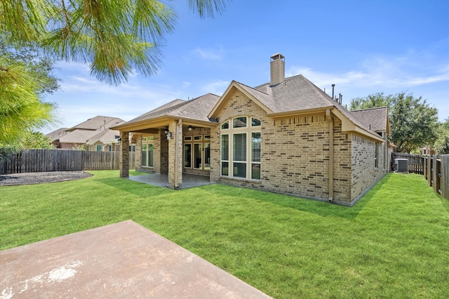 back of house featuring a patio and a yard