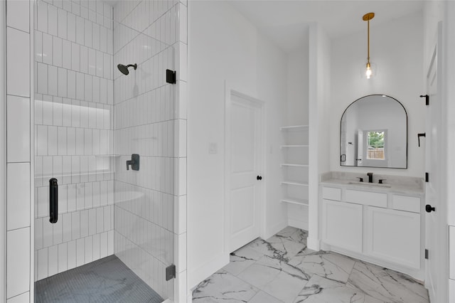 bathroom featuring a shower with door and vanity