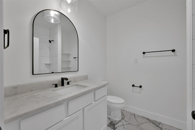 bathroom featuring toilet, vanity, and a shower