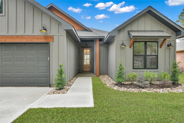 view of exterior entry with a lawn and a garage