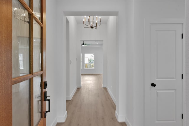 hall featuring a notable chandelier and light hardwood / wood-style floors