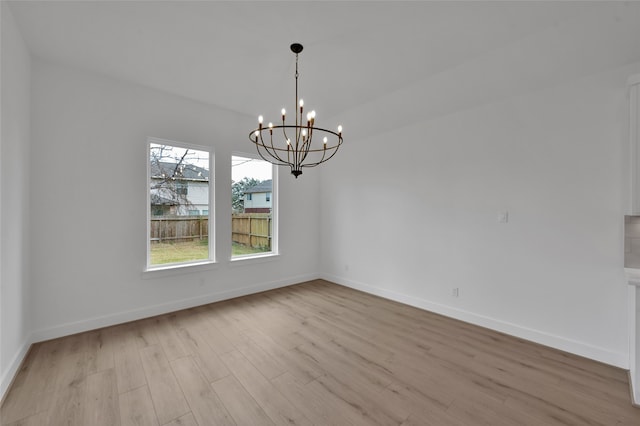 unfurnished dining area with light hardwood / wood-style flooring and a notable chandelier